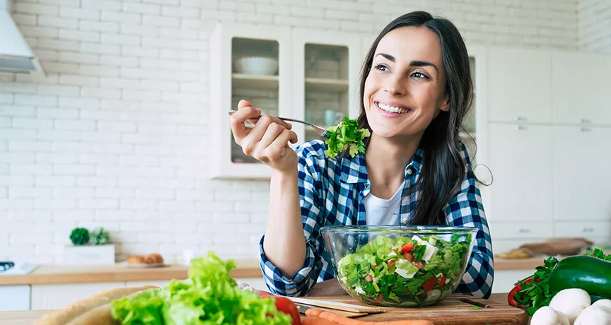 Mujer come una salada en su dia de home office