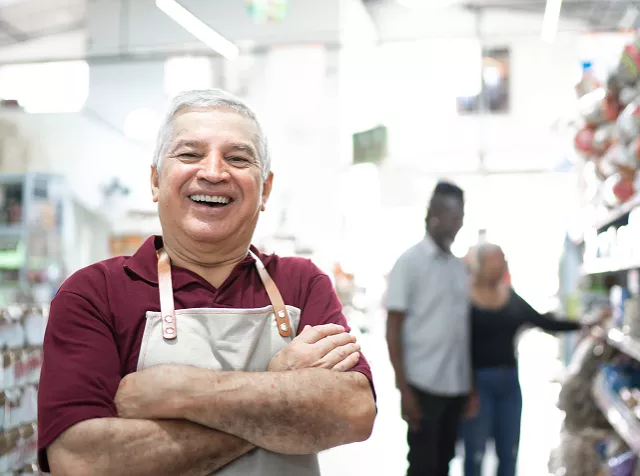 Un hombre mayor sonriente en su local