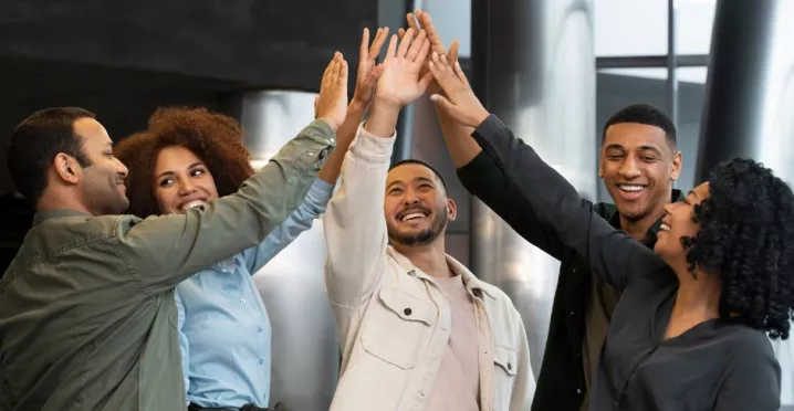 Grupo de colaboradores celebrando resultados del trabajo en equipo