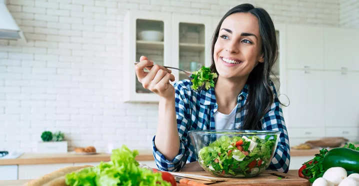 Mujer come una salada en su dia de home office