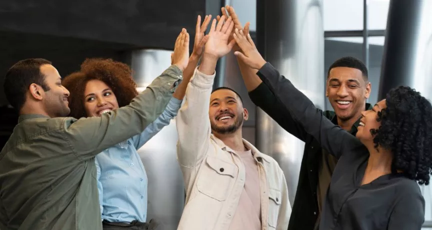 Grupo de colaboradores celebrando resultados del trabajo en equipo