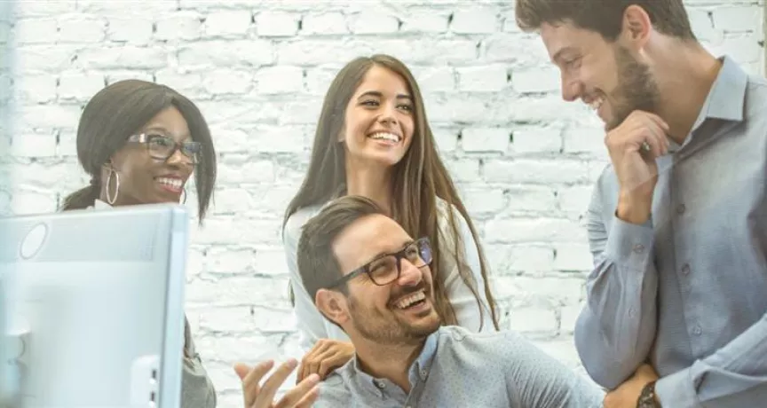 Colaboradores reunidos en un entorno laboral colaborativo, reflejando cultura organizacional y la importancia de tener un plan de retención de personal.