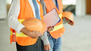 Trabajadores con chalecos de seguridad y cascos para prevenir riesgos de salud ocupacional