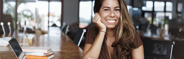 Mujer joven sonríe durante un intervalo en su trabajo