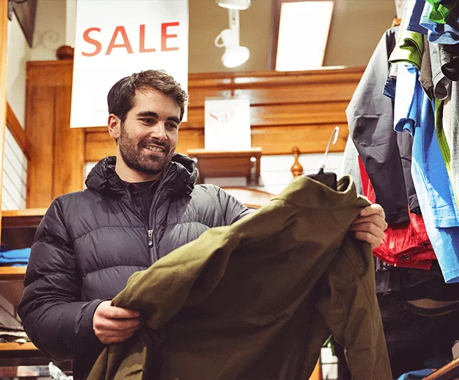 Imagen muestra un hombre comprando ropa