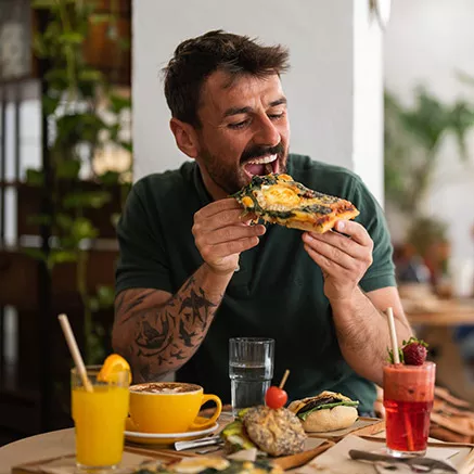 En la foto, una joven come un gran trozo de pizza en el almuerzo.