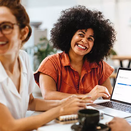 Una mujer sonríe durante una reunión de trabajo.